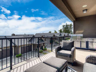 Enjoy outdoor living at its finest on this spacious balcony, complete with a built-in grill and comfortable seating.