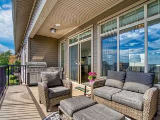 Enjoy outdoor living on this spacious balcony, complete with a built-in grill and comfortable seating.