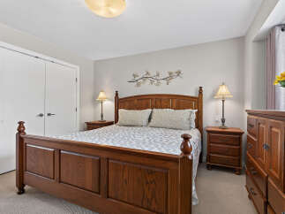 This inviting bedroom features a classic wooden bed frame with a patterned comforter and matching pillows.