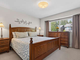 This inviting bedroom features a classic wooden bed frame complemented by a stylish patterned comforter and plush pillows.