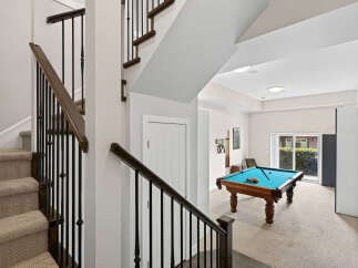 Step into a stylish basement recreation area featuring a vibrant pool table ready for game nights.