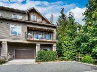 Discover this stunning townhouse featuring a modern exterior with horizontal siding and a prominent balcony.
