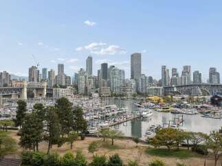 Experience waterfront living at its finest with this stunning view of a bustling marina and vibrant city skyline.