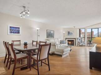 Experience elegant living in this spacious condo featuring a formal dining area with a wooden table and chairs, perfect for hosting.