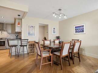 This dining area features a spacious wooden dining table with six chairs, perfect for family gatherings.