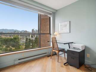 Enjoy breathtaking mountain and city views from this home office space, featuring a large window with blinds.
