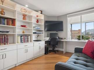 This bright and airy living space features a large built-in bookshelf perfect for displaying your favorite reads and decor.