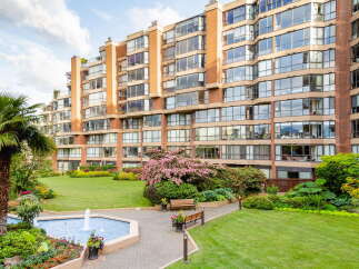 Discover elegant living in this stunning apartment complex, featuring a beautifully landscaped courtyard with a serene fountain and lush greenery.