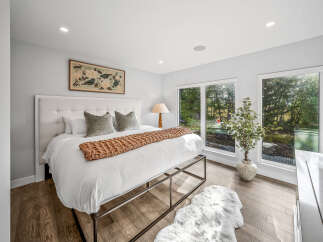 Experience luxury and tranquility in this stunning bedroom featuring a plush tufted headboard and a cozy knit throw.