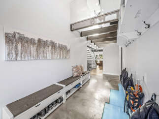 This modern entryway features a long, upholstered bench with built-in shoe storage, perfect for keeping the space tidy.