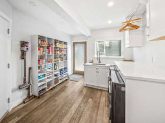 Discover this immaculate pantry and laundry area, featuring ample shelving for all your storage needs and a convenient sink for household tasks.