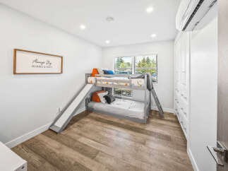 This charming bedroom features a space-saving bunk bed with a fun slide, perfect for kids.