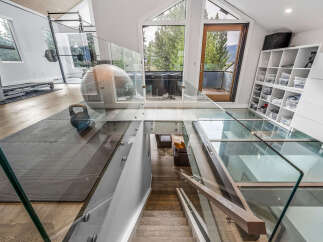 Experience luxury living in this modern home featuring a state-of-the-art home gym with a treadmill and weightlifting equipment.
