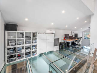 Discover a modern loft space featuring a unique glass floor, offering a contemporary aesthetic and an open-concept feel.