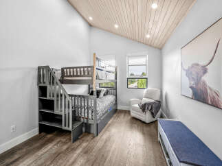 This charming bedroom features a stylish gray bunk bed with integrated storage, perfect for maximizing space.