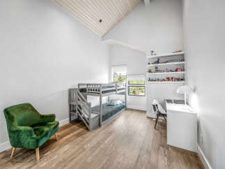This bright and airy bedroom features a stylish grey bunk bed with comfortable bedding, perfect for siblings or sleepovers.