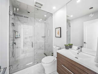 Experience modern luxury in this stunning bathroom featuring a spacious glass-enclosed shower with marble tile and a sleek rain showerhead.