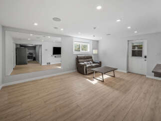 Discover this spacious living area featuring a comfortable recliner and a rustic coffee table, perfect for relaxation.