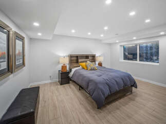 Discover comfort and style in this beautifully appointed bedroom, featuring a plush navy comforter and a rustic wooden headboard.