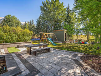 Enjoy outdoor living with this spacious patio featuring a picnic table and benches, perfect for al fresco dining.