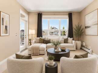 Experience modern living in this beautifully staged living room, featuring a plush sectional sofa and two accent chairs perfect for relaxation and entertaining.
