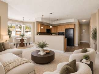 Experience modern living in this beautifully staged open-concept condo, featuring a spacious living area with a cozy sectional and plush armchairs perfect for relaxation.