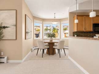 Enjoy bright and airy dining in this charming space, featuring a round wooden table with four upholstered chairs, perfect for intimate gatherings.