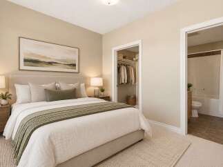 Discover comfort and convenience in this beautifully appointed bedroom, featuring a plush king-sized bed and a serene landscape artwork above.
