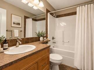 This charming bathroom features a spacious vanity with a double sink and ample counter space, perfect for busy mornings.