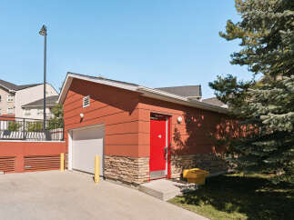 Discover this charming property featuring a vibrant red door and a convenient garage, perfect for any homeowner.