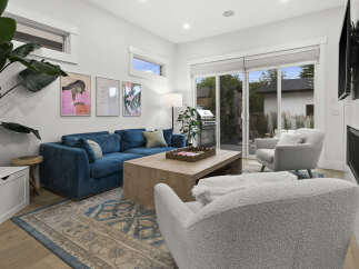 Experience modern living in this stunning living room, featuring a plush blue sectional sofa and comfortable boucle armchairs perfect for relaxation.