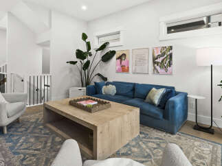 Experience modern living in this bright and airy living room, featuring a plush blue sofa and a stylish wooden coffee table perfect for gatherings.