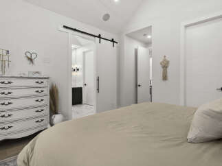 Discover this charming bedroom featuring a stylish white dresser adorned with decorative hardware and a jewelry stand.