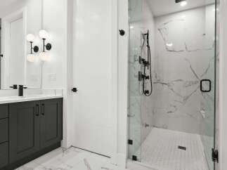 Experience modern luxury in this stunning bathroom featuring a sleek dark vanity with a marble countertop and a stylish black faucet.
