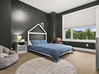This charming bedroom features a playful house-shaped bed frame, perfect for a child's dream space.