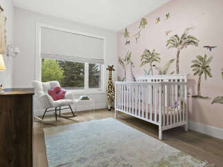 Welcome to this charming nursery, featuring a whimsical jungle-themed wallpaper that sparks imagination.