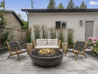 Experience ultimate relaxation in this modern backyard oasis, featuring a sleek concrete fire pit surrounded by comfortable seating.