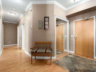 Step into this inviting entryway featuring a warm wood floor and a comfortable bench perfect for removing shoes.