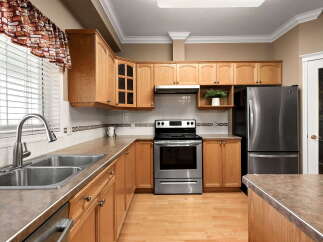 Discover this charming kitchen featuring warm oak cabinetry and sleek stainless steel appliances.