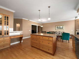 This spacious open-concept living area features a well-appointed kitchen with a large island, ample cabinetry, and a built-in desk area.