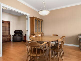 This inviting dining room features a classic wooden dining set with a round table and four chairs, perfect for intimate gatherings.