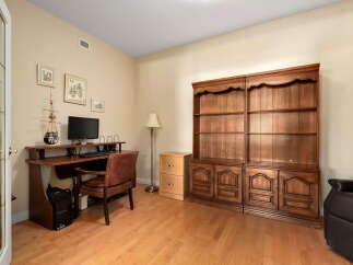 This home office features a classic wooden desk with a computer setup and a comfortable leather chair, perfect for productivity.
