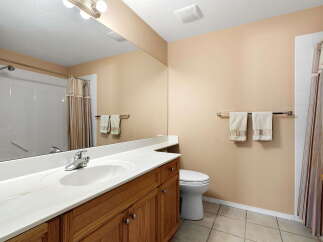 This bathroom features a spacious vanity with a white countertop and ample storage below.