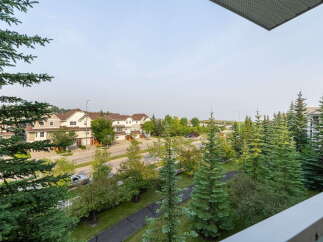 Enjoy the serene neighborhood views from this property, featuring charming townhouses and lush greenery.