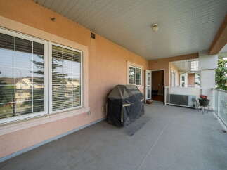 Enjoy outdoor living on this spacious covered balcony, perfect for entertaining or relaxing.