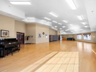 This spacious room features a beautiful polished wood floor, perfect for dancing or events.