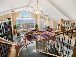 Experience breathtaking panoramic views from this stunning property, featuring a grand staircase and soaring vaulted ceilings.