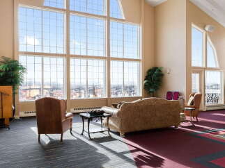Experience breathtaking panoramic views from this stunning living space, featuring expansive floor-to-ceiling windows that flood the room with natural light.