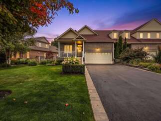Experience elegant living in this stunning property featuring a beautifully manicured lawn and a welcoming front porch.