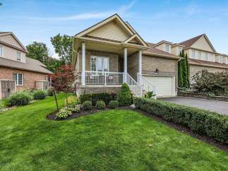 Discover this charming brick home featuring a welcoming covered porch with white railings, perfect for enjoying your morning coffee.